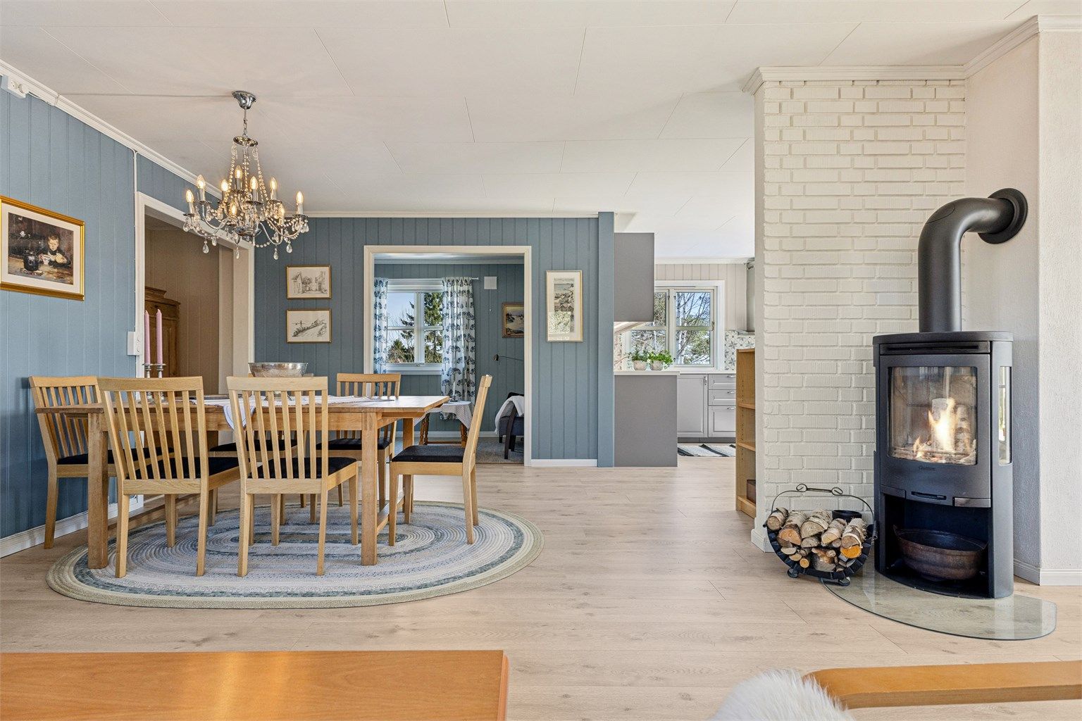Lys og gjennomgående stue i 1. etasje med peisovn og god plass til spisebord.
