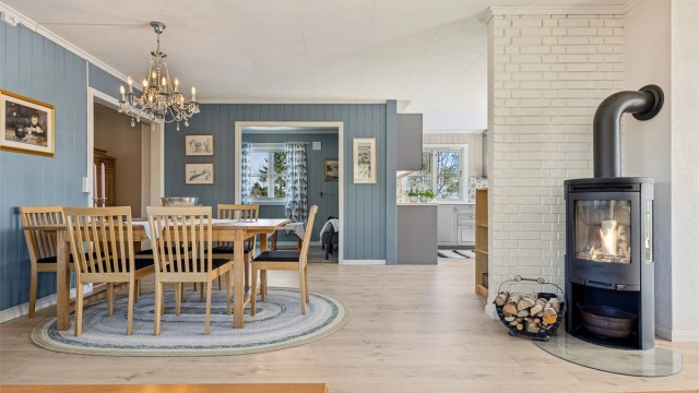 Lys og gjennomgående stue i 1. etasje med peisovn og god plass til spisebord.