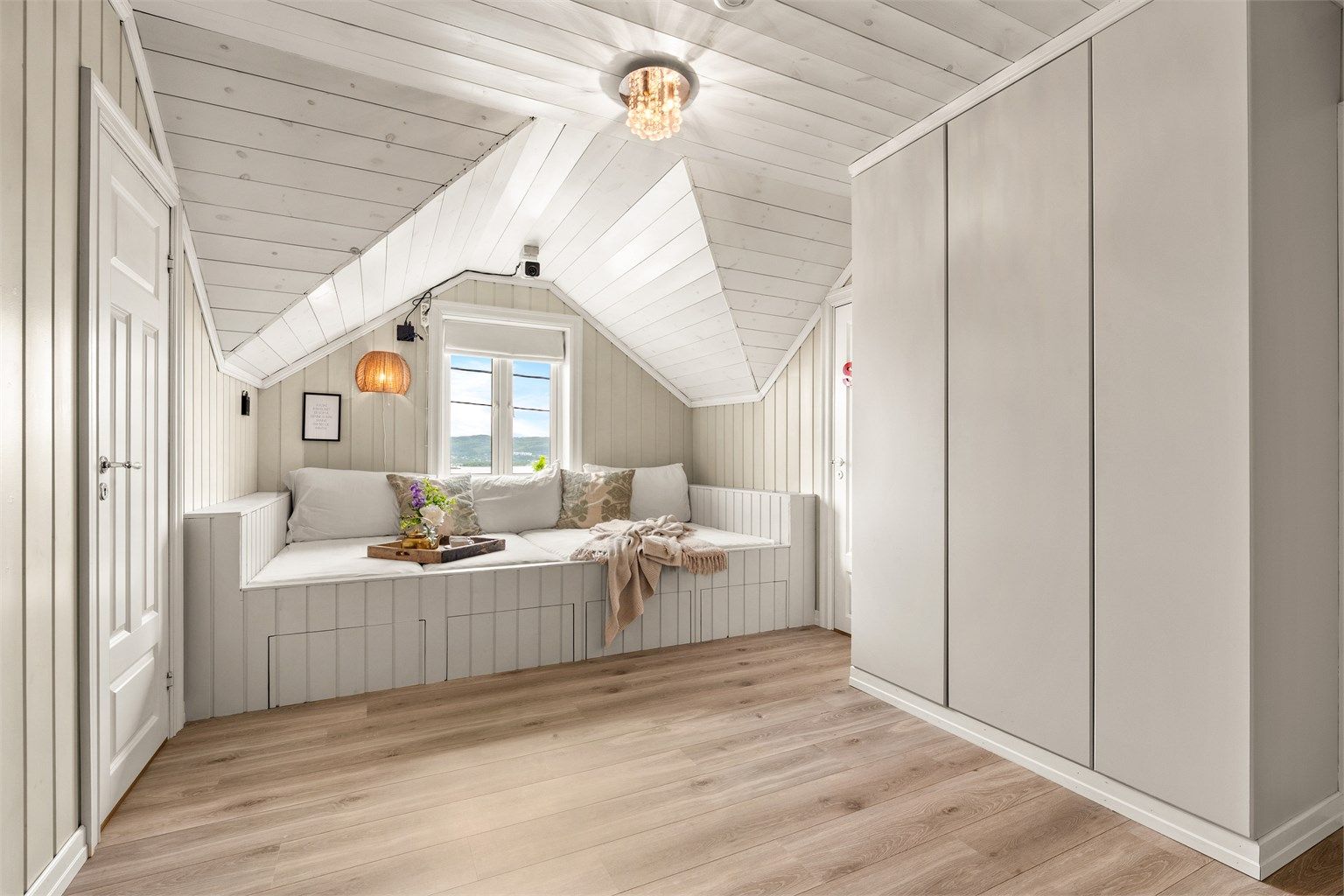 En plassbygd sittebenk med oppbevaring utnytter plassen under skråtaket optimalt.
