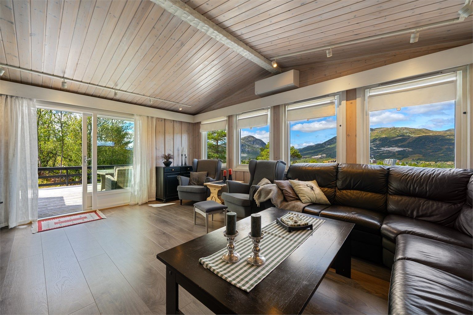 Stue med flott utsikt og store vindusflater. Utgang solrik veranda. Varmepumpe.