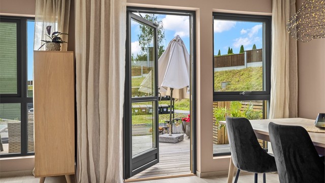 Fra stuen er det utgang til en romslig terrasse og hage.