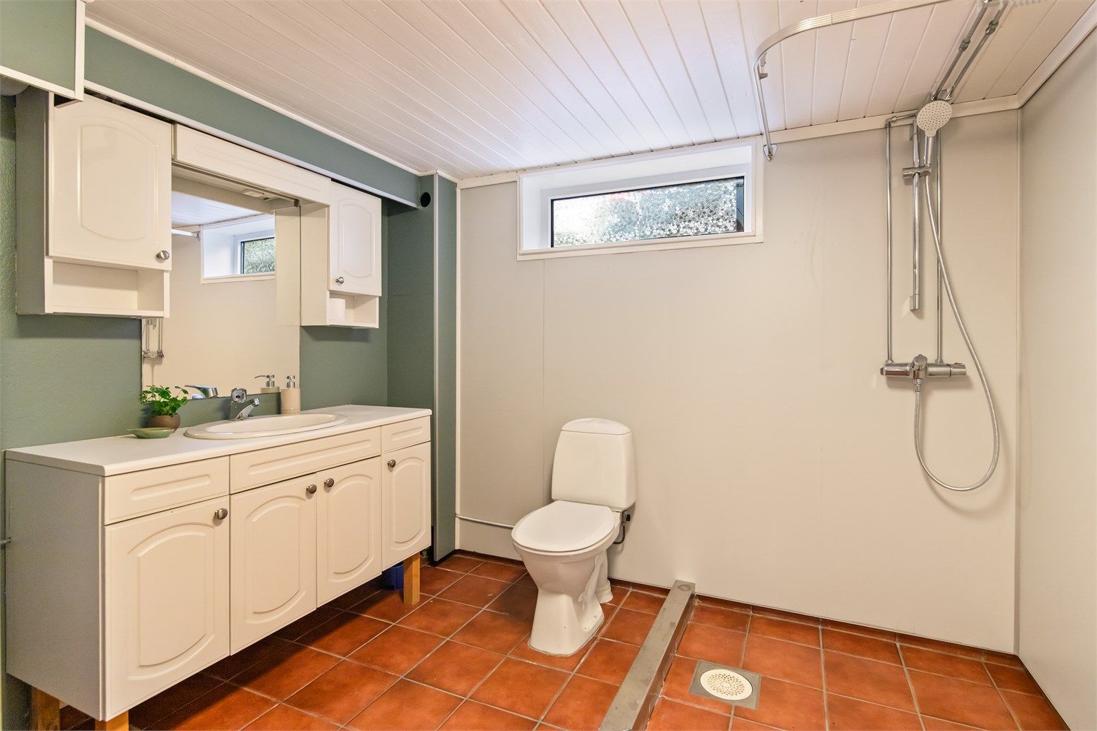 Badet i kjelleretasjen mot øst har fliser på gulvet og veggflater med malte flater og baderomsplater.