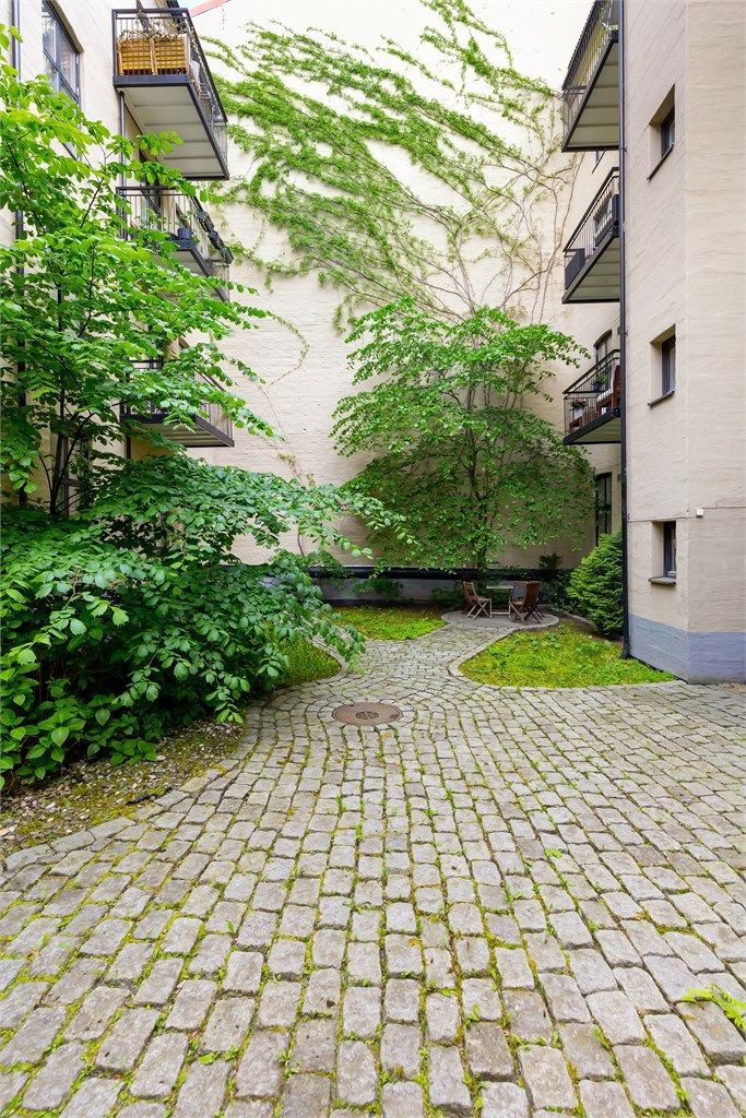 Tomten er opparbeidet med brostein og beplantning.
