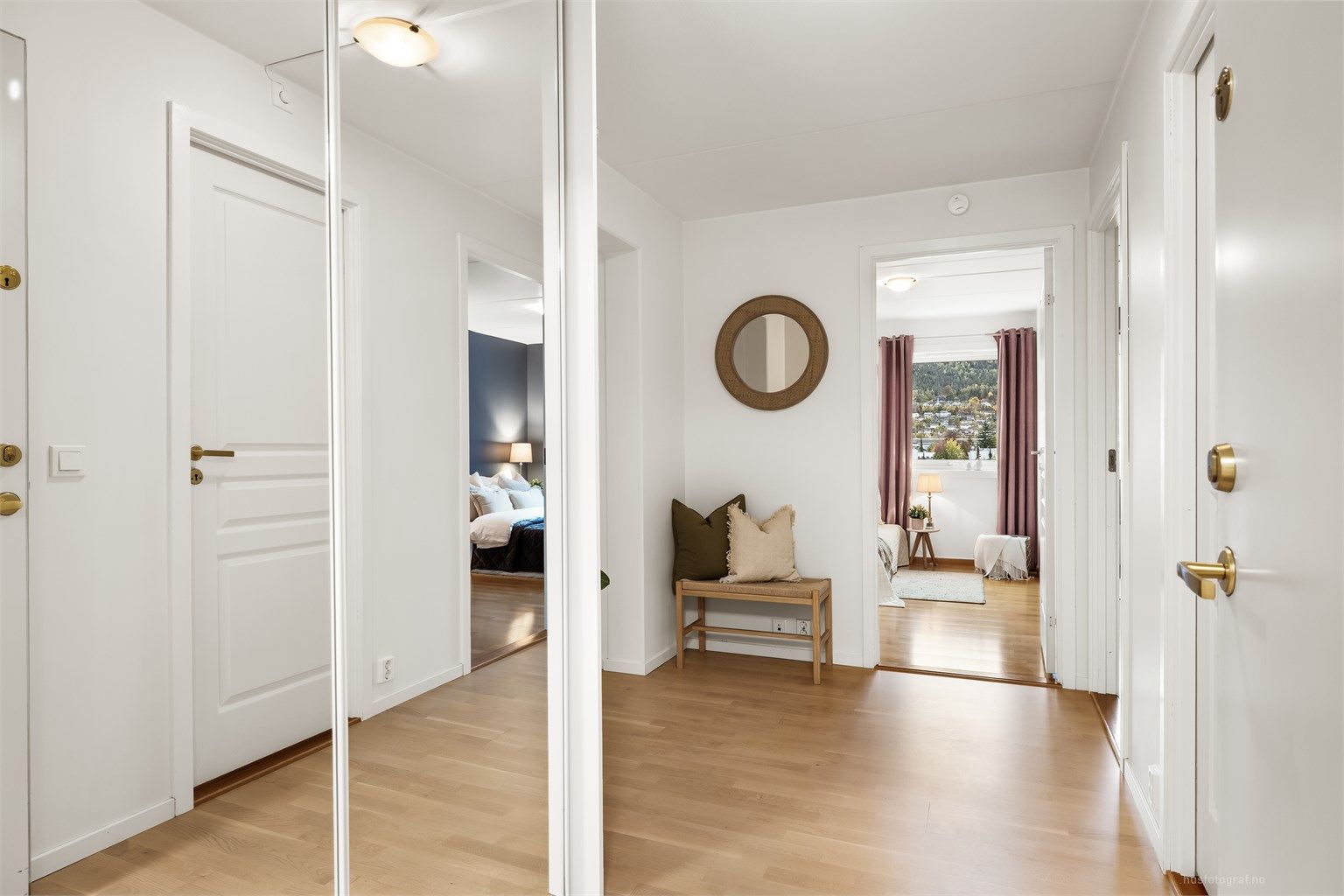 Dørcallinganlegg med åpnerfunksjon og plassbygget skyvedørsgarderobe med speilfronter i entré.
