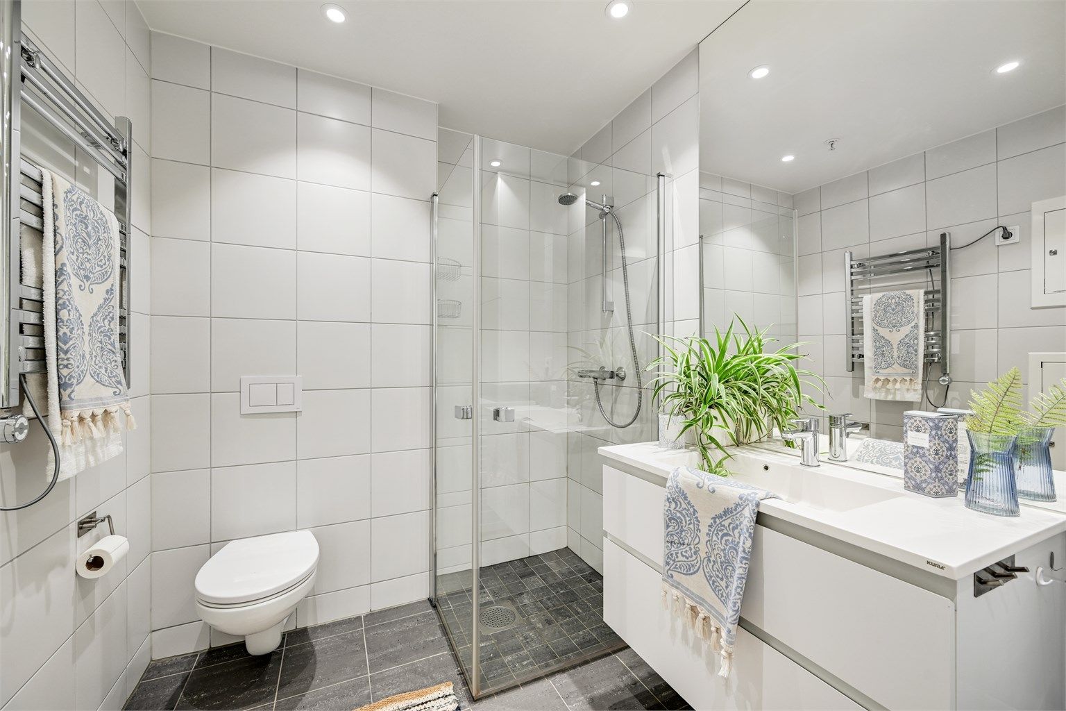 Badet er romslig med dusj og wc samt en nisje med opplegg til vaskemaskin og tørketrommel. 