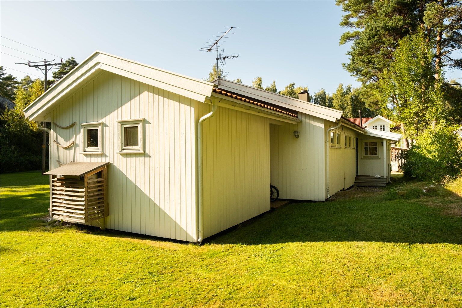 Inngangspartiet og svalgangen foran uteboden er begge skjermet mot nedbør.