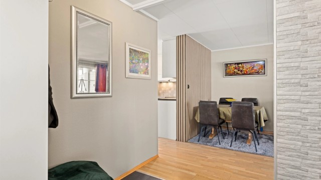 Fra entreen åpner boligen seg opp mot stuen, som har en dekorativ spilevegg.