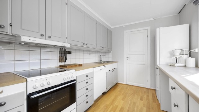 Kjøkkenet i hovedetasjen har en tidløs innredning med profilerte fronter og godt med skap- og benkeplass.