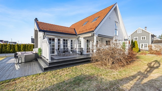 Oversiktsbilde av eiendommen med den store terrassen og hagen.