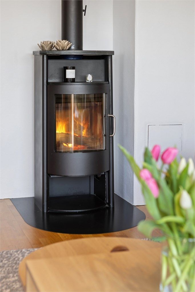 I stuen finner du en moderne og tidløs peisovn i støpejern, med effektiv varmefordeling og et stilrent uttrykk som løfter interiøret.