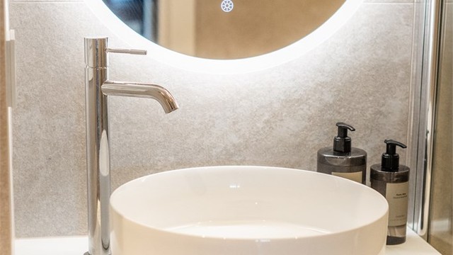 Servantskap med ovenpåliggende servant og speil med integrert belysning og forskjellige fargetoner.