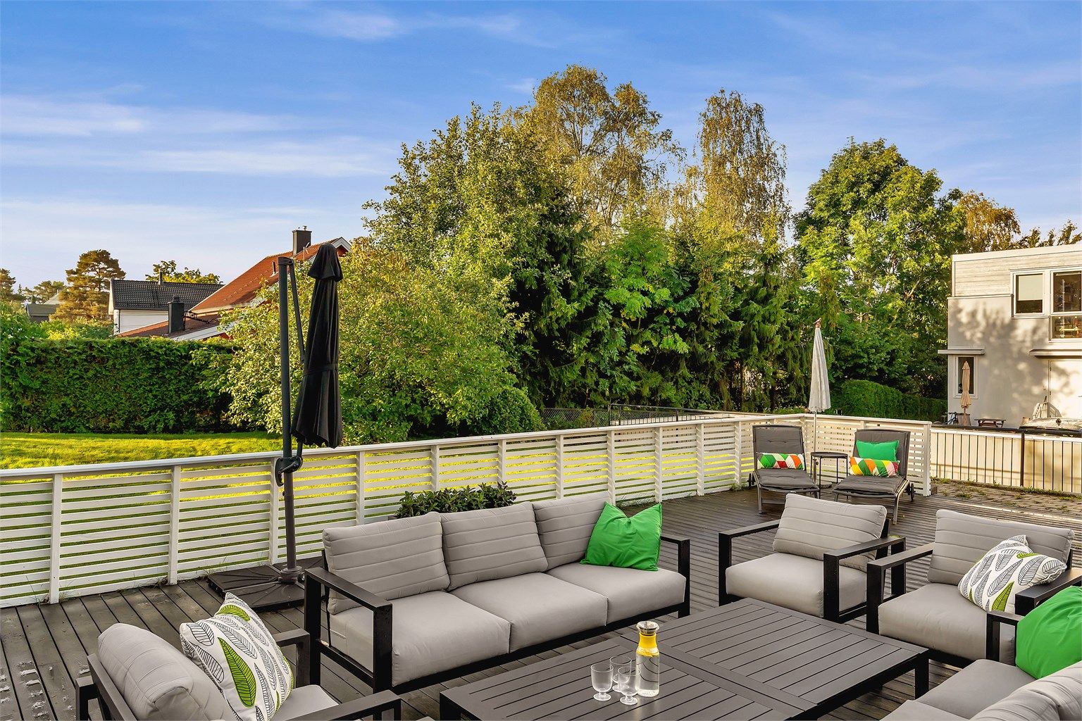 Hagen på baksiden er opparbeidet med flislagt gulv og stor Kebony platting. Uteområdet er inngjerdet