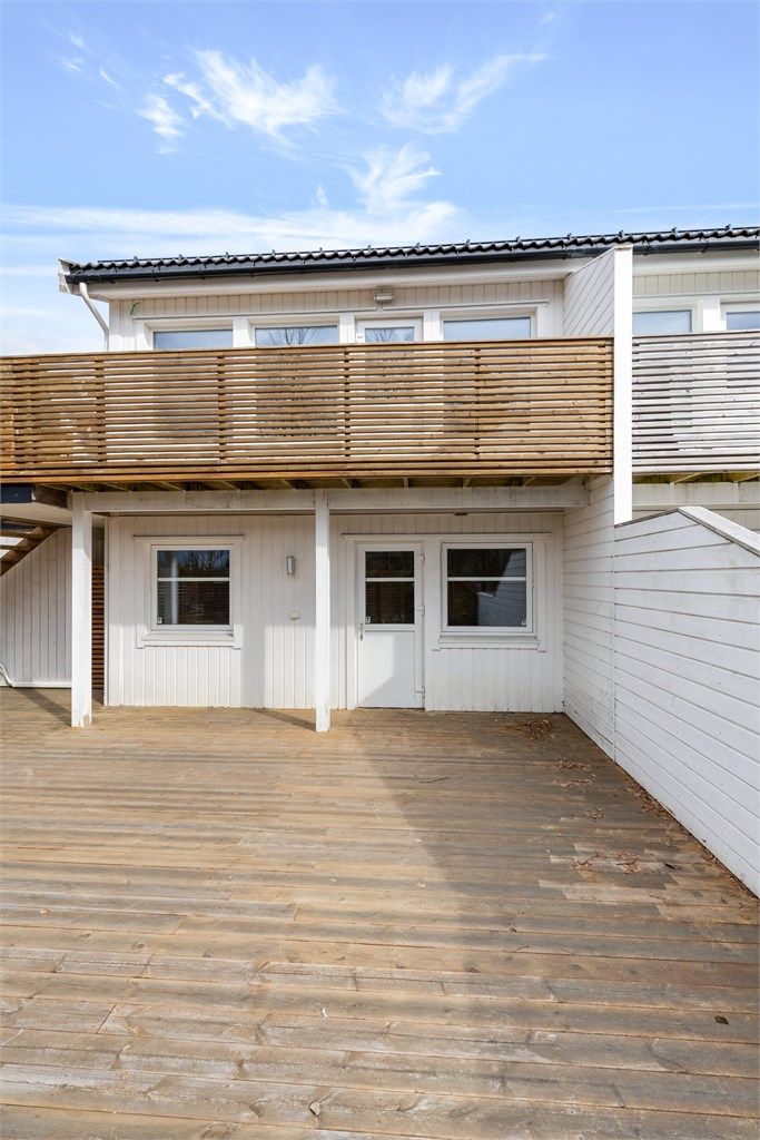 Den vestvendte terrassen på 53 m² har direkte adkomst fra ett av soverommene i første etasje og fra svalgang mellom hus og carport.