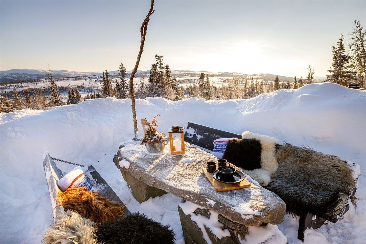 Uteplassen er et sosialt samlingspunkt med langbord i stein og bålpanne for stemningsfulle kvelder.