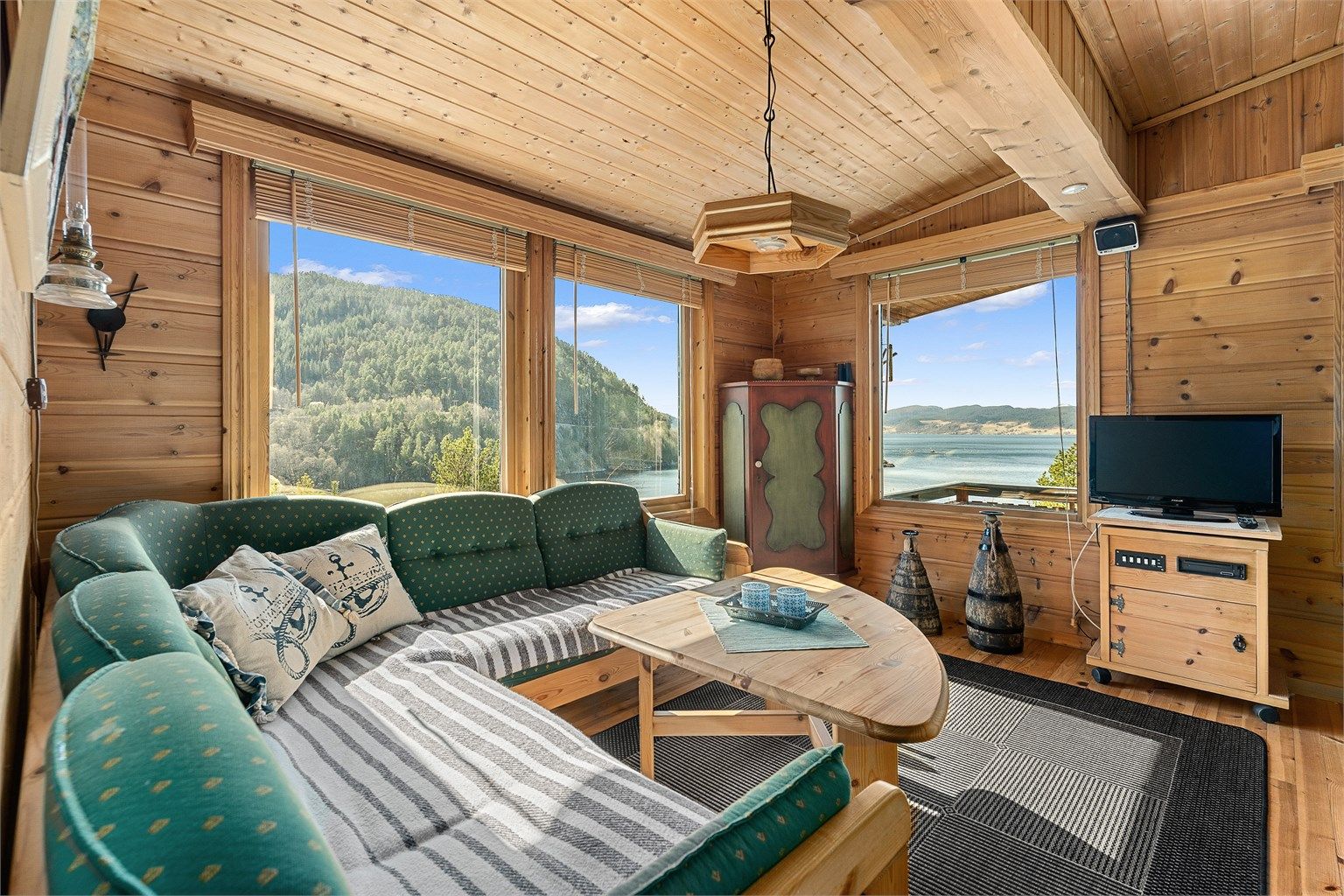 Lys og lun stue med store vindusflater som slipper naturen inn og gir en fantastisk romfølelse.