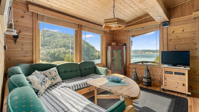 Lys og lun stue med store vindusflater som slipper naturen inn og gir en fantastisk romfølelse.