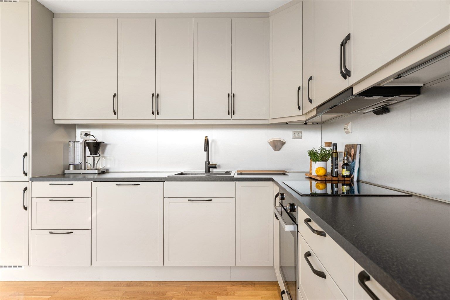 Kjøkkenet har integrert stekeovn, platetopp, oppvaskmaskin og kjøleskap med fryser. Ventilator i overskap.