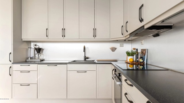 Kjøkkenet har integrert stekeovn, platetopp, oppvaskmaskin og kjøleskap med fryser. Ventilator i overskap.
