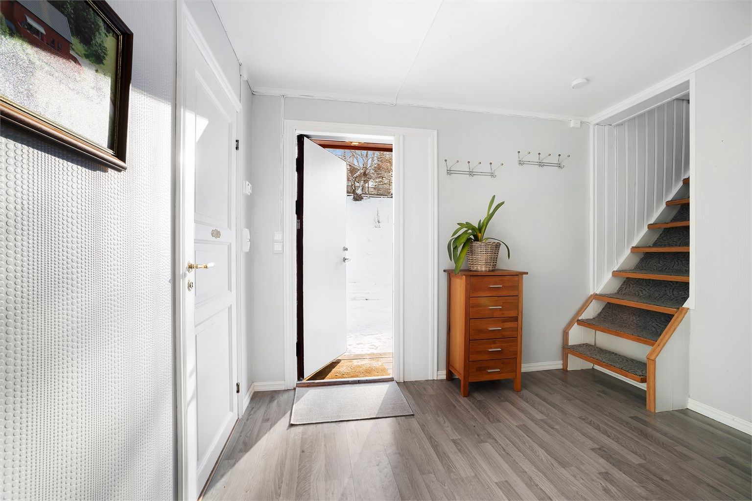 Inngangspartiet ønsker velkommen inn i boligen og har trapp opp til andre etasje.