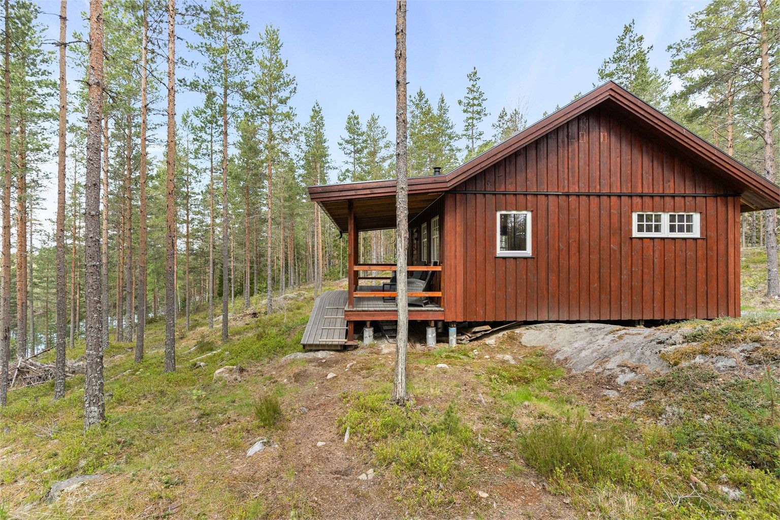 Skogshusværet har et overbygd inngangsparti og er fundamentert på betongsøyler på fjell.