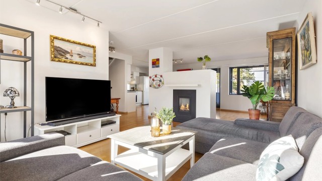 Romslig stue med flere møbleringsalternativer. Her er det plass til sittegruppe og TV-område. Den åpne løsningen mellom stue, spisestue og kjøkken skaper en sosial atmosfære når man er med venner og familie.