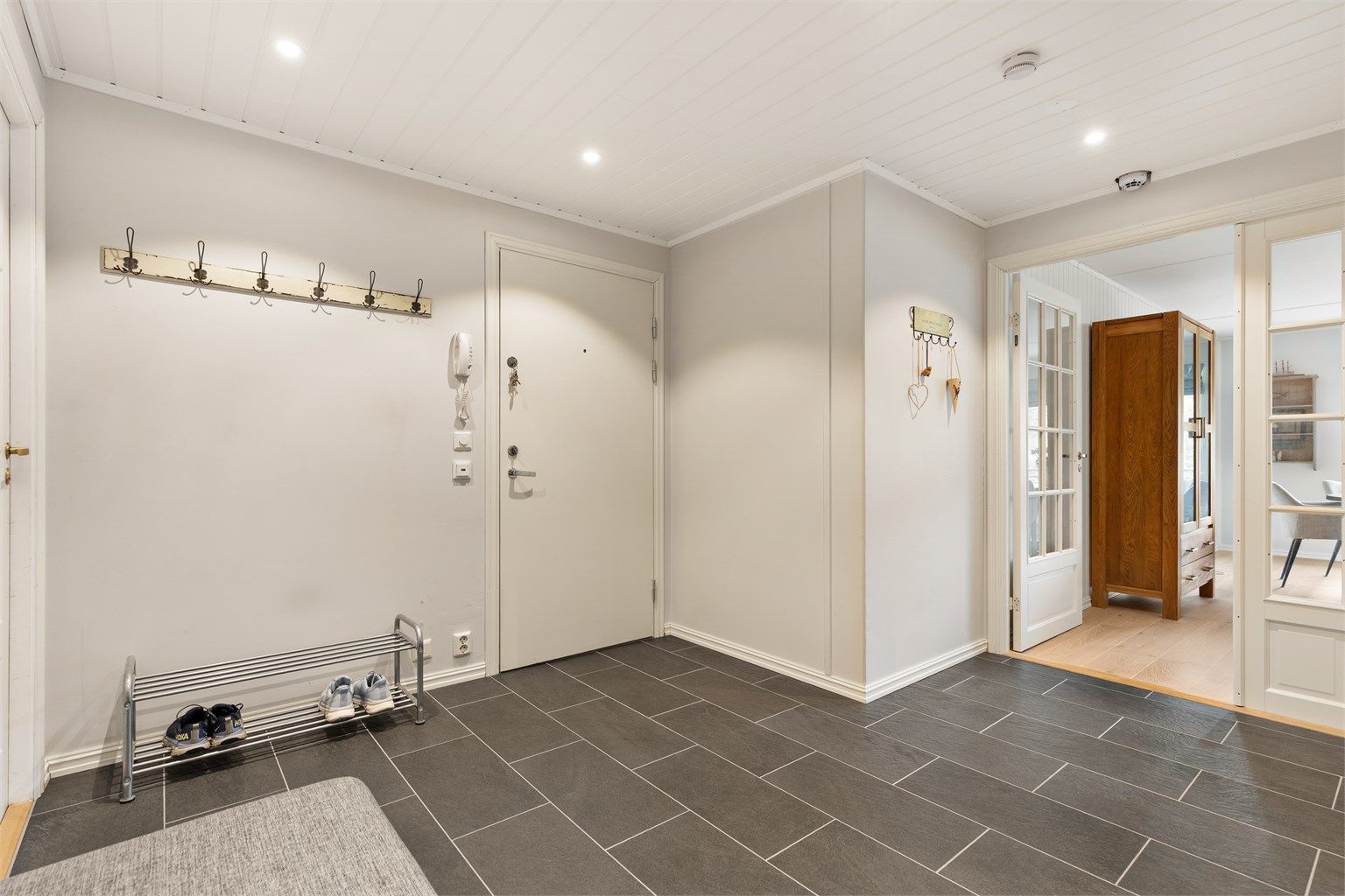 Stor entré med god plass til oppbevaring, fliser på gulv med gulvvarme og downlights i taket. Fra entréen er det videre adkomst inn i til kjøkkenet, stuen, begge soverom, samt bad og wc.