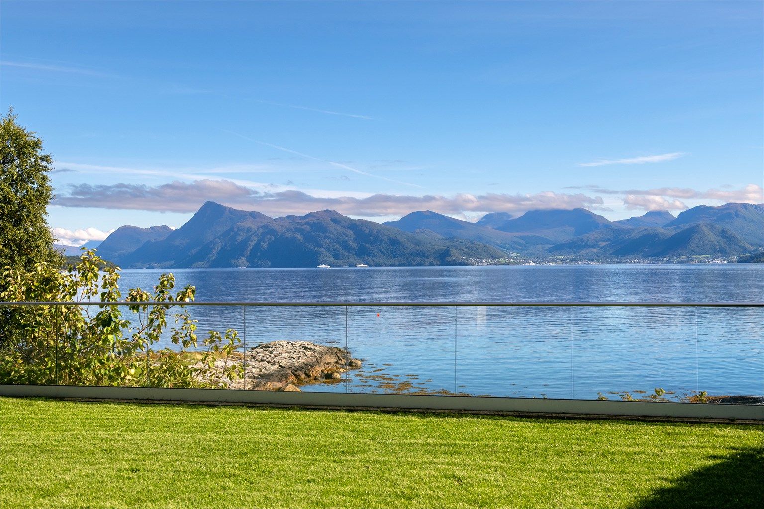 Utsikt mot Storfjorden og fjellformasjonene i Sunnmørsalpene. Idylliske omgivelser med oter, hvaler og delfiner jevnlig i vannbassenget utenfor. 