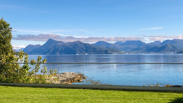 Utsikt mot Storfjorden og fjellformasjonene i Sunnmørsalpene. Idylliske omgivelser med oter, hvaler og delfiner jevnlig i vannbassenget utenfor.