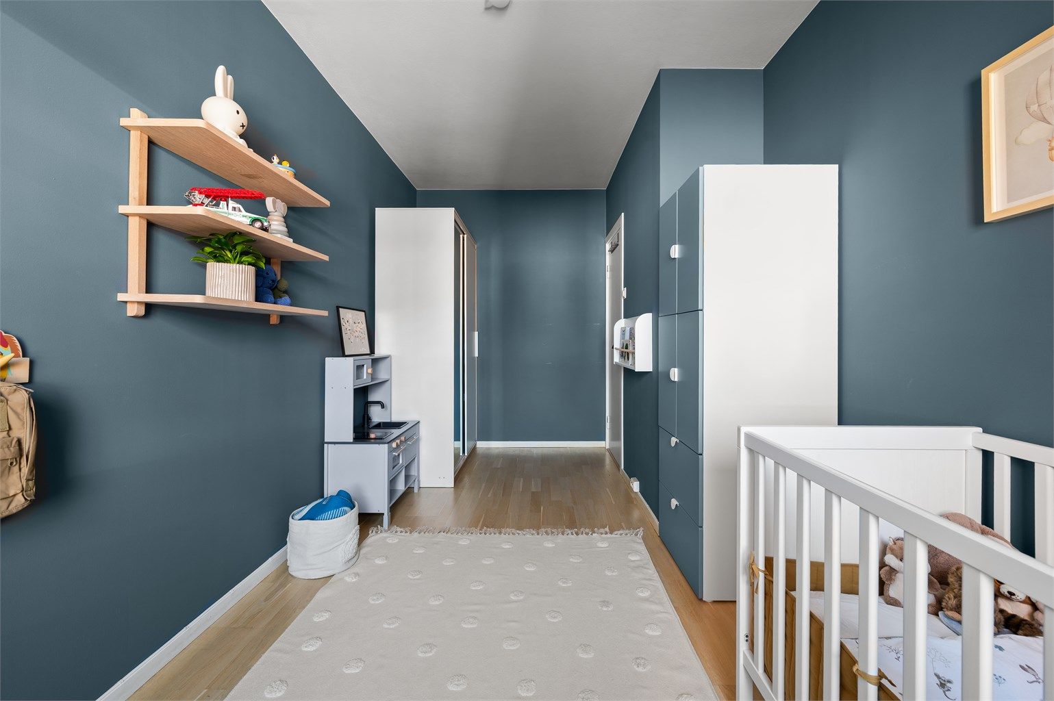 Gjennomgående laminatgulv og lyse, malte veggflater binder rommene sammen.