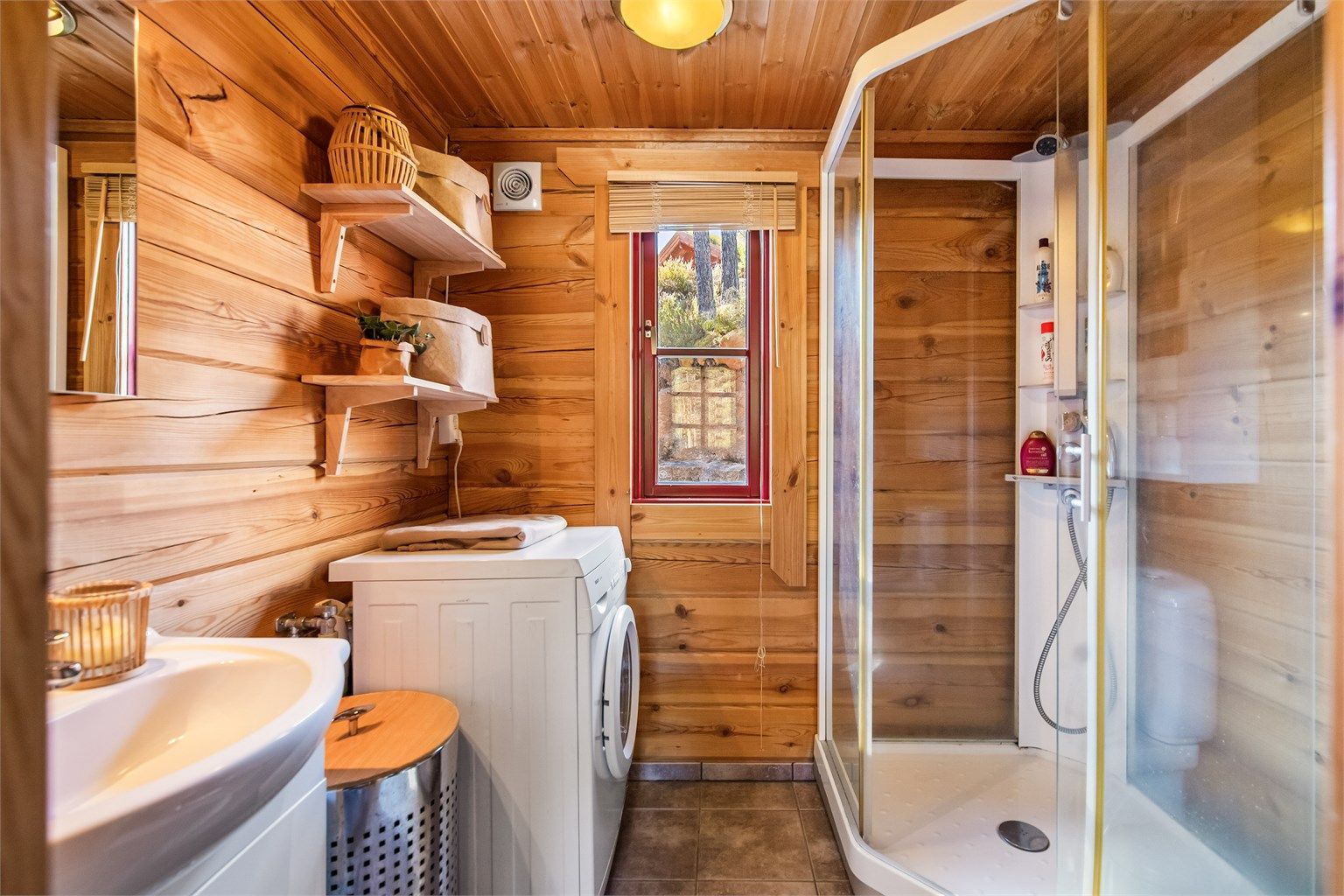 Badet er innredet med wc, dusjkabinett, servant og opplegg til vaskemaskin