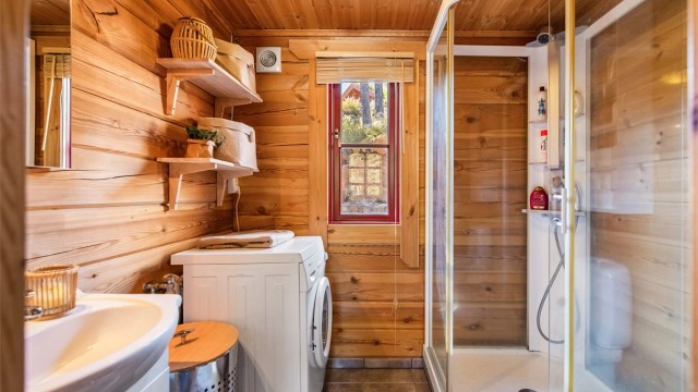 Badet er innredet med wc, dusjkabinett, servant og opplegg til vaskemaskin