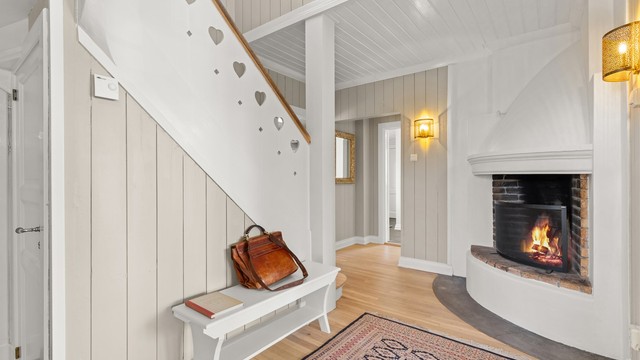 Den unike hallen setter umiddelbart tonen for resten av boligen. Allerede her møter du mye av husets karakter og sjarme. Den stemningsfulle peisen gir rommet en lun og innbydende atmosfære