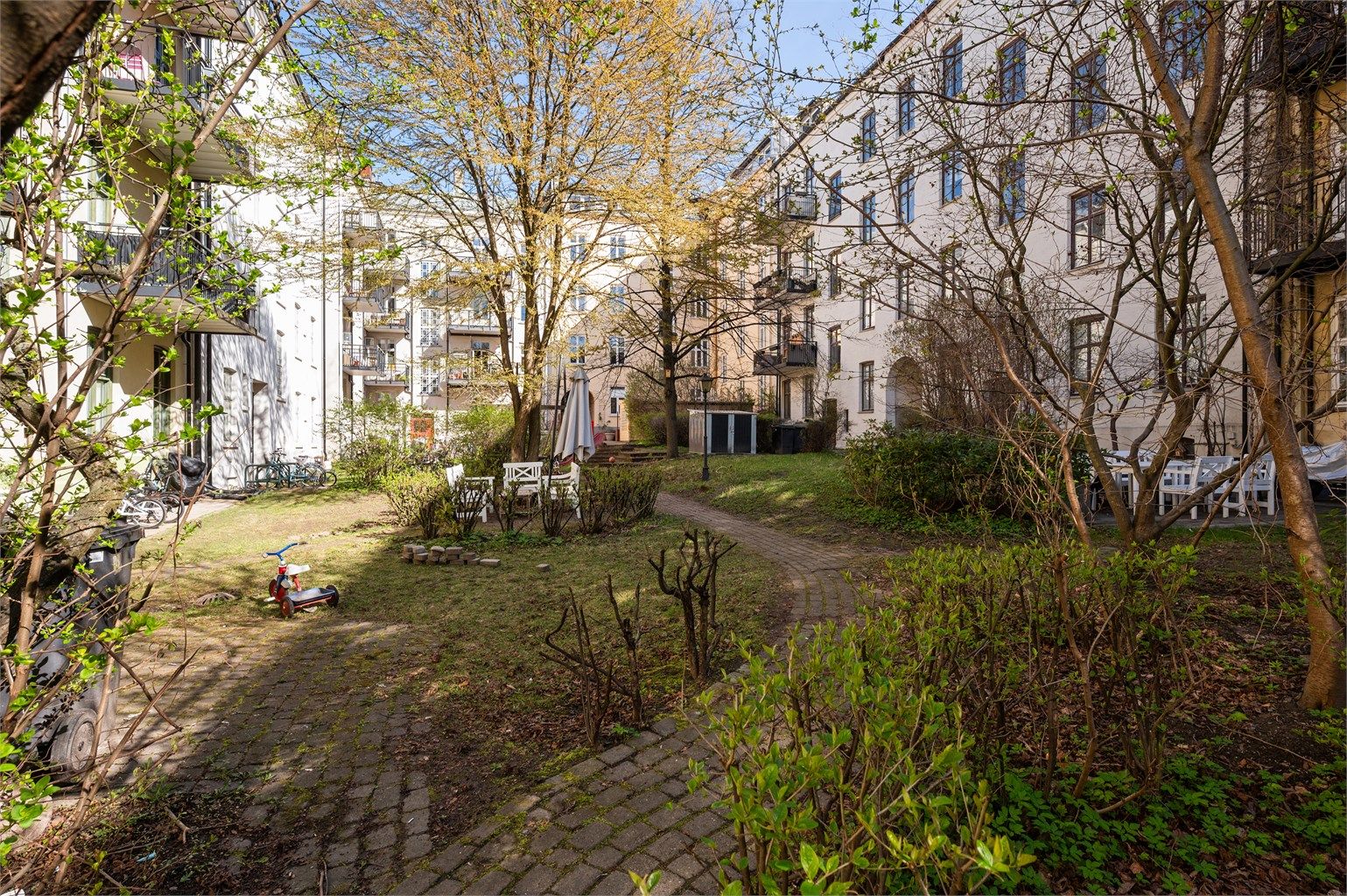 Den sjarmerende bakgården er en frodig oase for beboerne, med sittegrupper og god plass for rekreasjon.