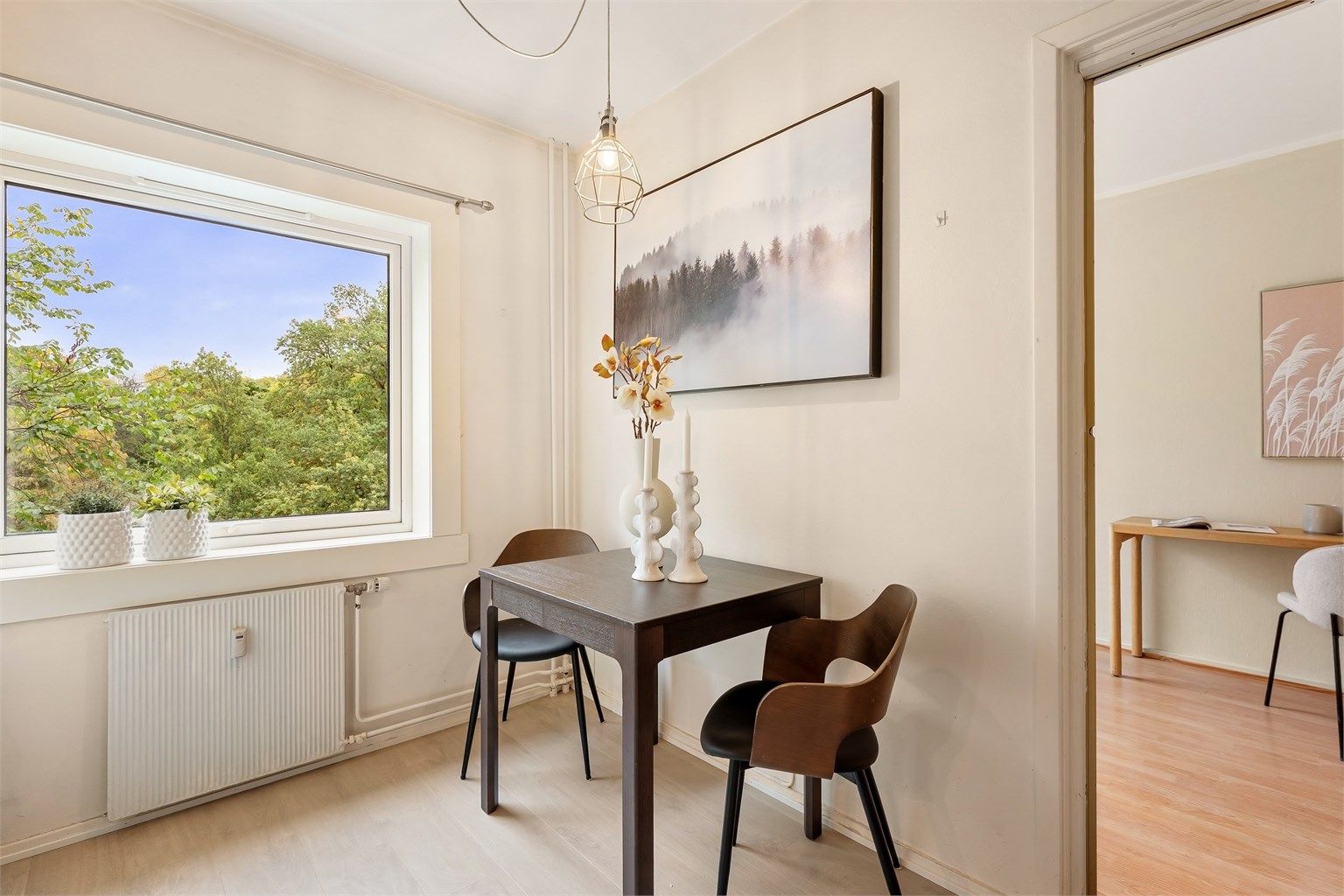 Spiseplass på kjøkkenet med utsikt mot grønne omgivelser.
