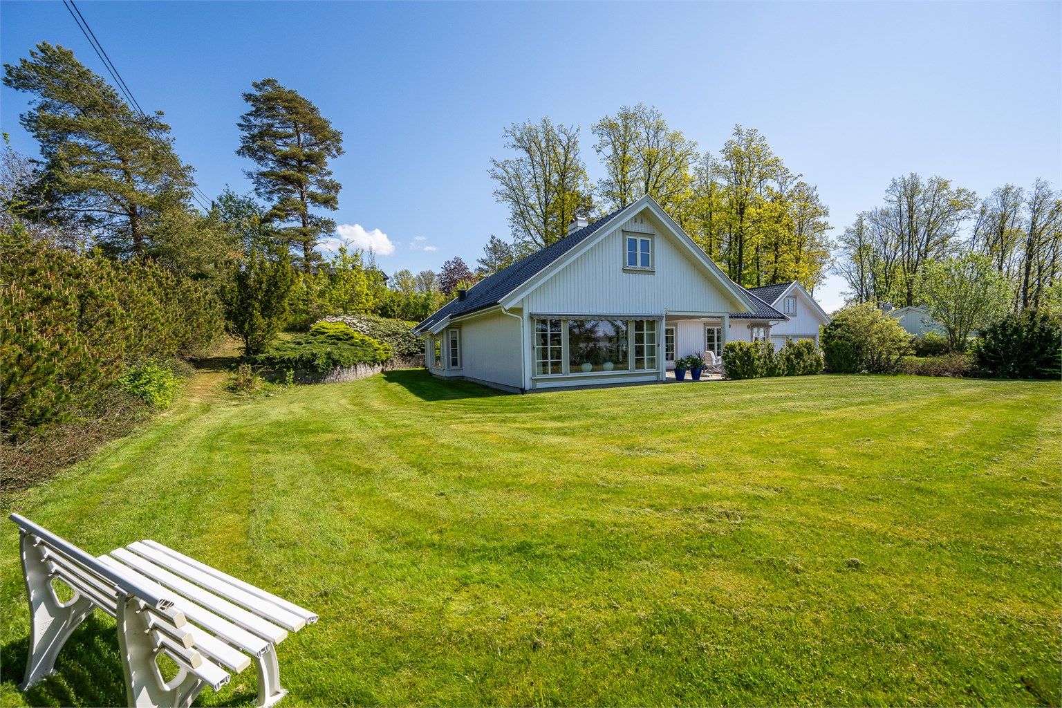 Stor og solrik hage som omkranser boligen.