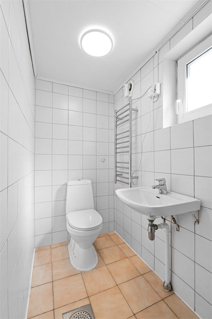 Badet er utstyrt med gulvstående toalett og dusj.
