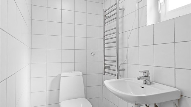 Badet er utstyrt med gulvstående toalett og dusj.