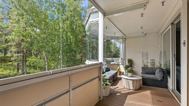 Store skyvebalkongdører skaper en naturlig forbindelse mellom stuen og den romslige balkongen.