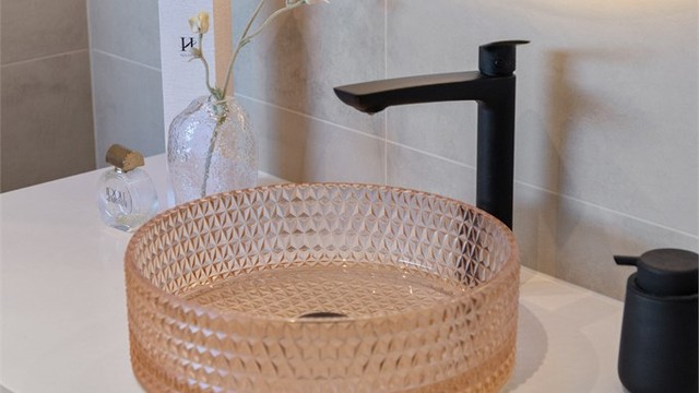 Rommet har flislagte overflater, gulvvarme, innfelte spotter og moderne innredning med dusjnisje.