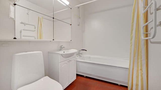 Bad - belegg på gulv - baderomsinnredning (servant med underskap og speilskap) - badekar - toalett
