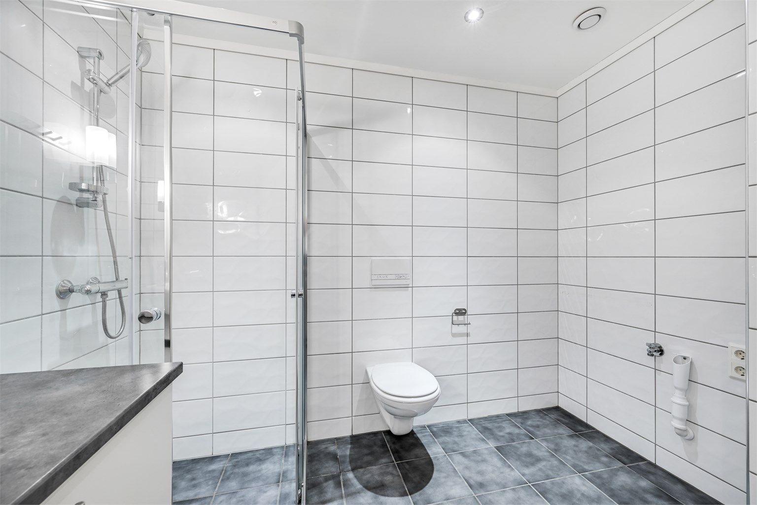 Badet har opplegg for vaskemaskin og tørketrommel.