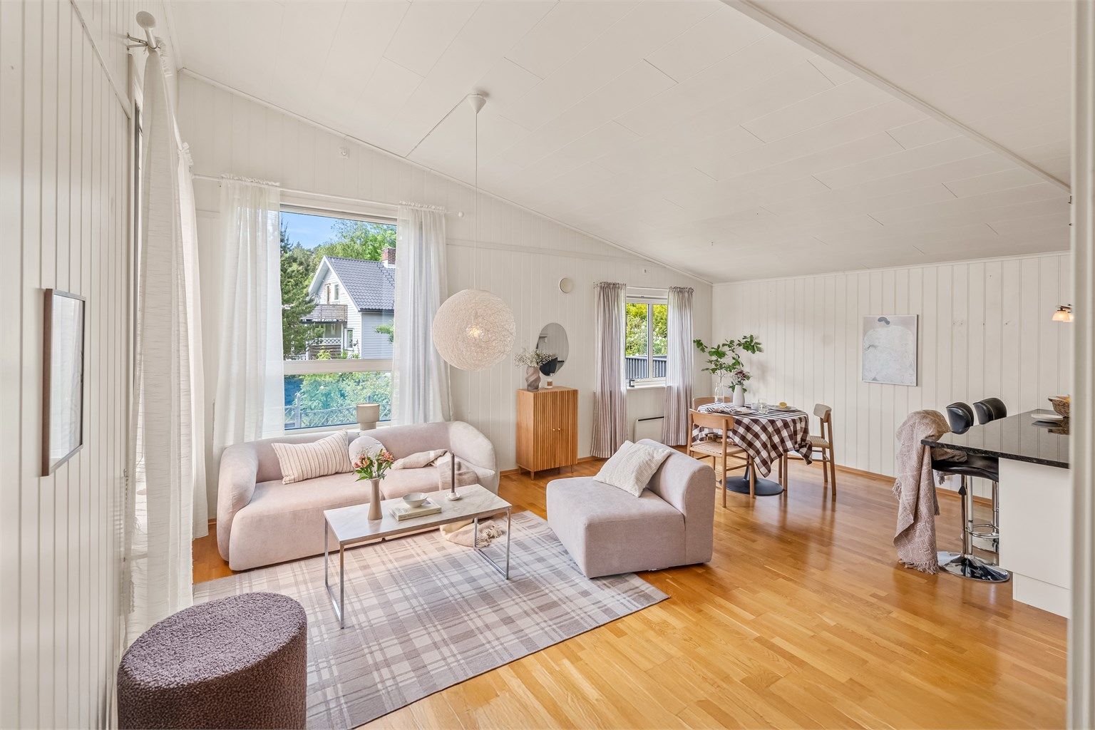 Inne i stuen er det god takhøyde og mange vindusflater som slipper inn godt med naturlig lys