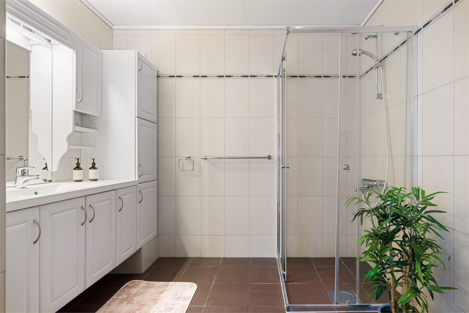 Badet er oppgradert rundt 2010 og har flislagte overflater, gulvvarme og servantskap med overskap og speil med lys.