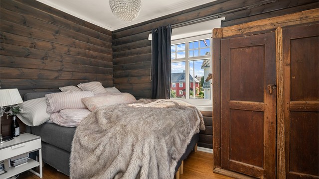 Romslig hovedsoverom med lune materialvalg og god plass til dobbeltseng og øvrig møblement.