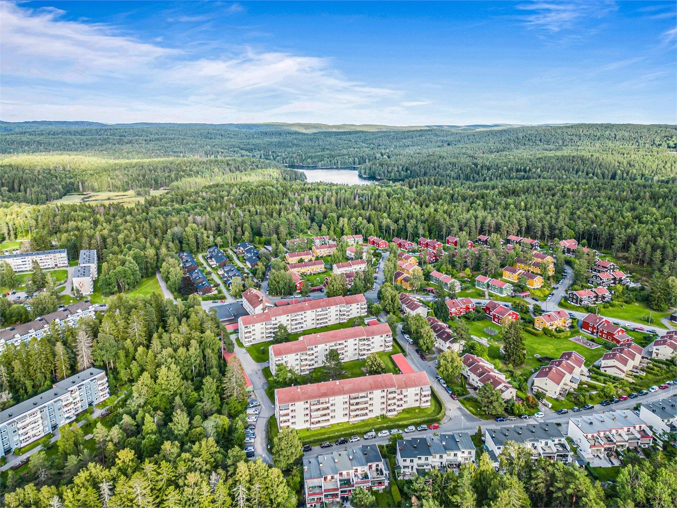 Dronebilde av blokka og nærområdet med kunsterboligene og vakre Østmarka og Nøklevann.