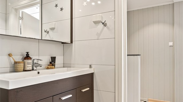 Badet har dusjkabinett og opplegg for vaskemaskin.