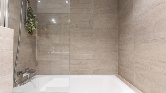 Badekaret er utstyrt med svingbar glassvegg og regndusj.