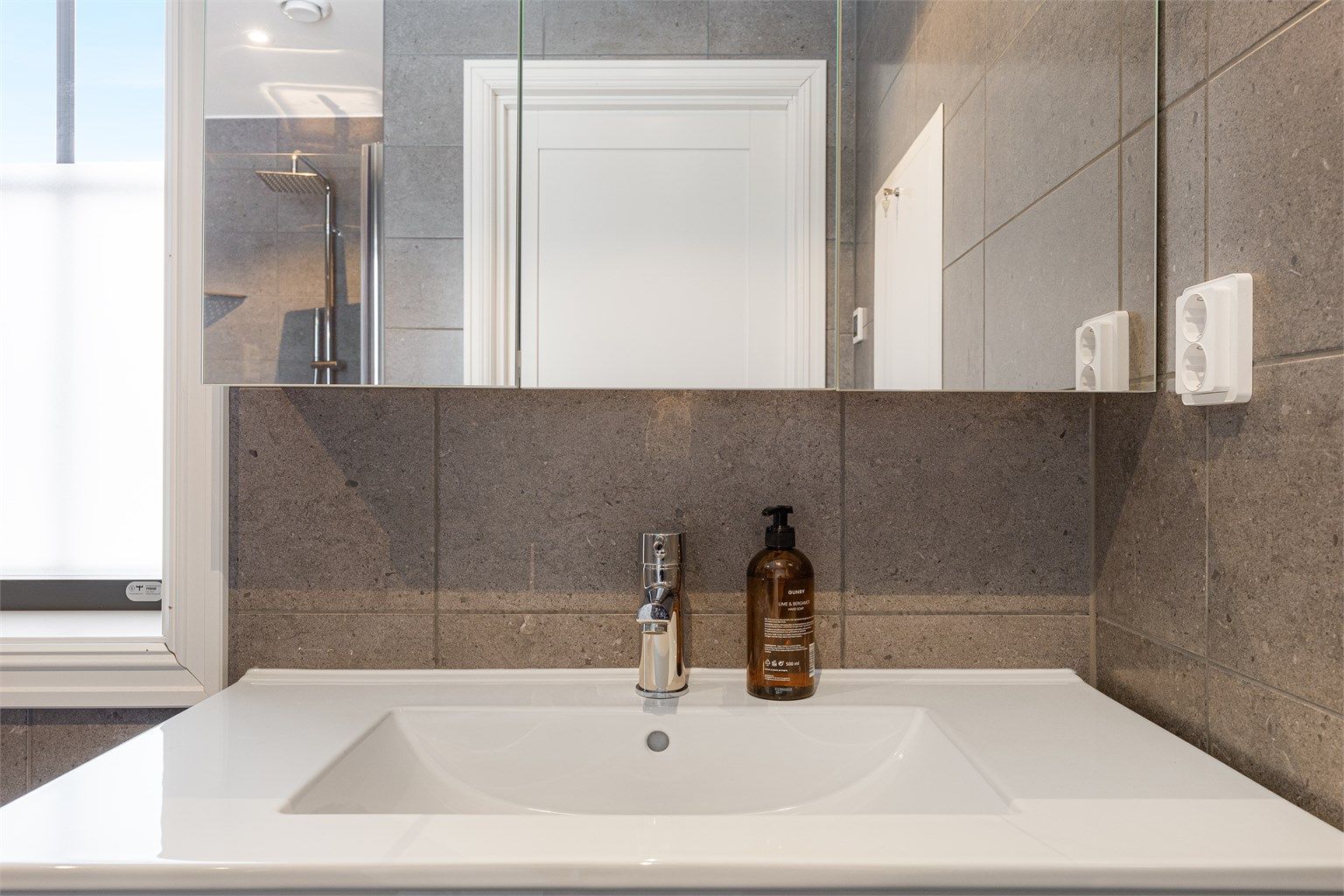 Et stort speilskap med integrert belysning gir godt lys og ekstra oppbevaring.