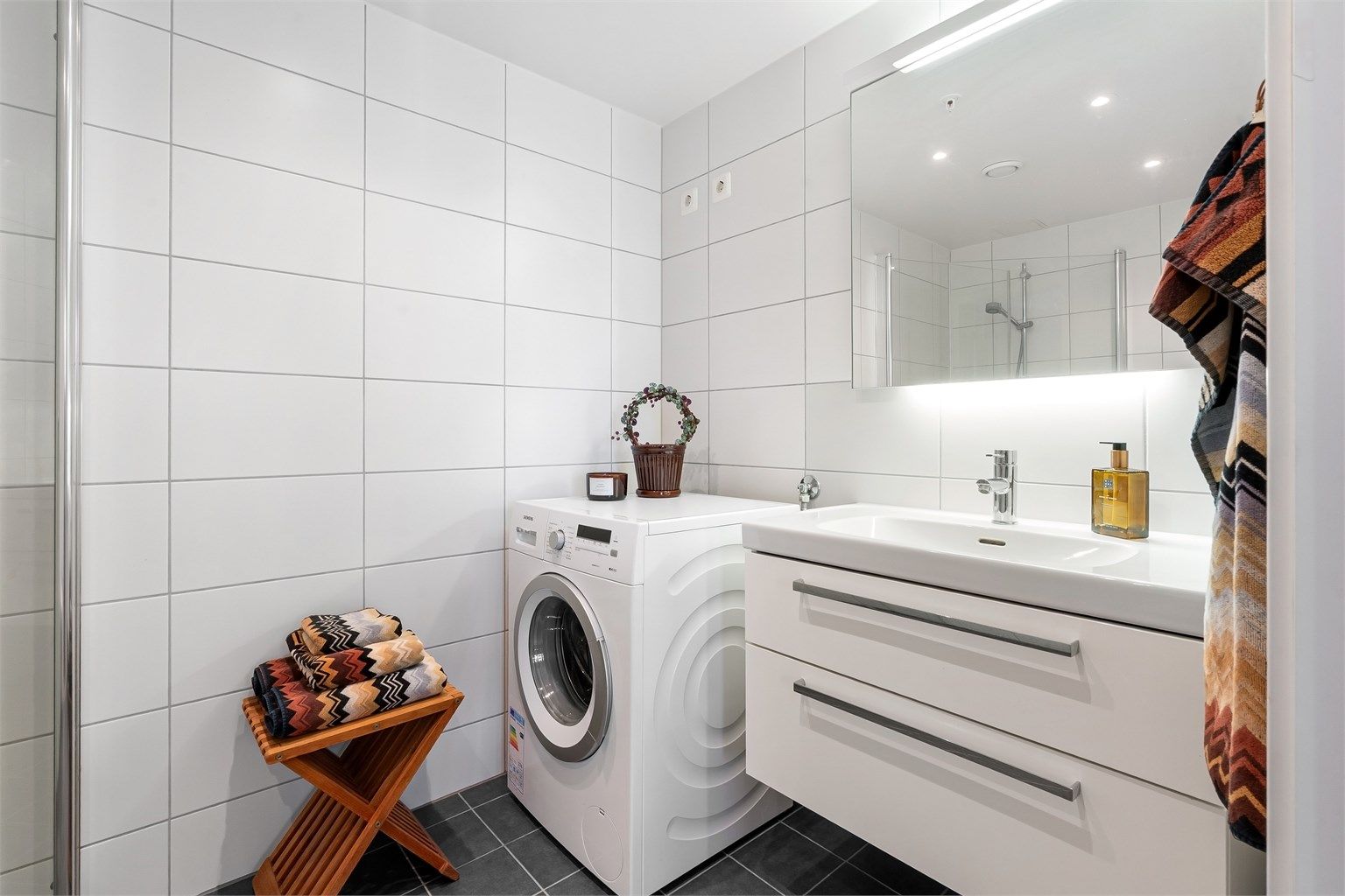 Delikat, flislagt bad fra byggeåret med varme i gulvet og opplegg for vaskemaskin.