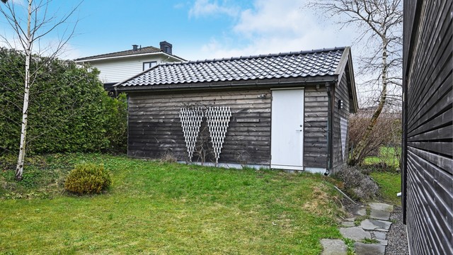 Den frittstående boden på 17 m² er en ombygget garasje som gir svært gode lagringsmuligheter.